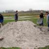 Den angelieferten Sand zum Auffüllen der Kuhlen auf dem Platz, zuerst einmal Umladen.